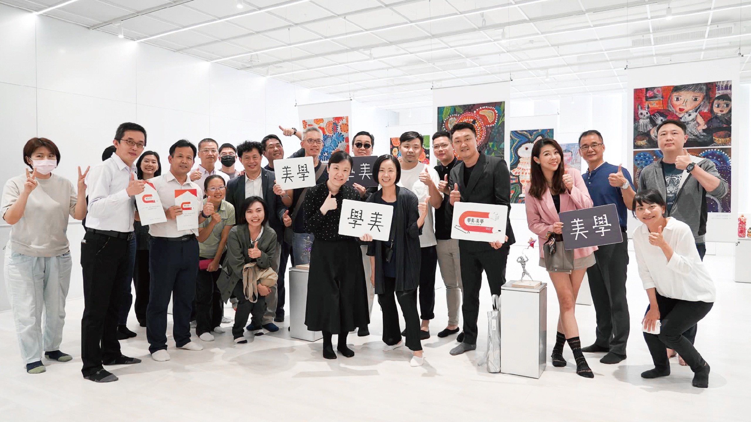 學美．美學校園美感設計實踐計畫成果發表合影：與會者持「學美」「美學」手牌於學生作品展區合影